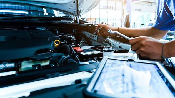 Automechaniker prüfen den Zustand des Autos monatlich. Zur Kontrolle nutzt der Techniker das Tablet.